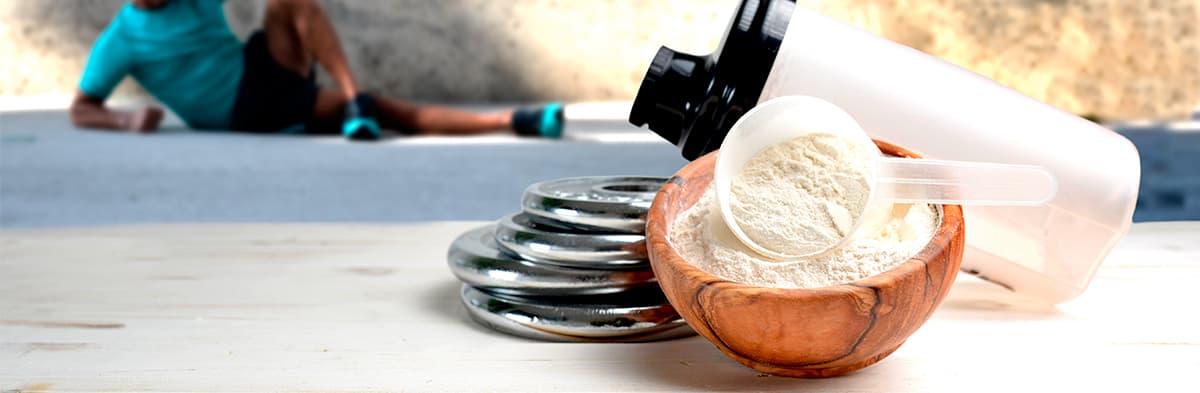 whey isolate en premier plan avec un homme qui fait du sport en arrière plan