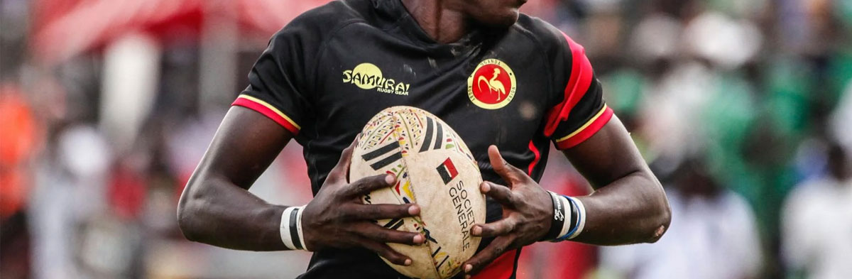 Rugbyman habillé en noir avec un ballon